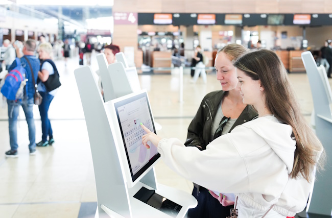 Fluggäste am Online Check-In in BER