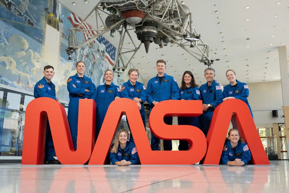 Bild mit den zehn neuen Astronauten vor dem NASA Logo