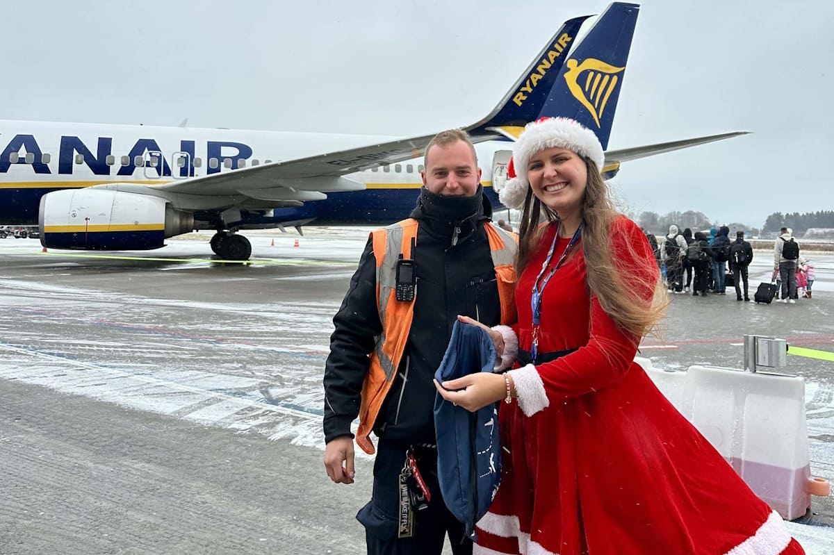Mitarbeiter und Weihnachtsfrau vor dem Flugzeug